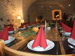 a long table with red napkins on top of it at Le Domaine du Grand Cellier Chambres d'hôtes en Savoie in Tournon