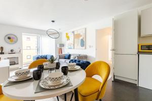 a kitchen and living room with a table and chairs at Stunning Station Apartment with free Parking in Kent