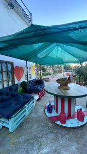 a patio with couches and a table with a large umbrella at Refúgio dos Mauzinhos in Ourondo
