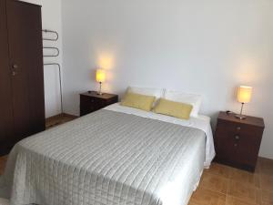 a bedroom with a white bed with two night stands at Casa da Bisa in Sagres
