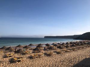 a group of umbrellas and chairs on a beach at Casa da Bisa in Sagres
