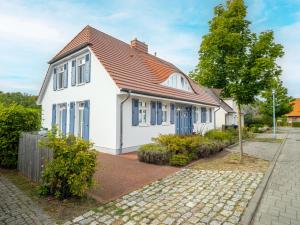 ein weißes Haus mit einem roten Dach in der Unterkunft Haus SEEGARTEN in Wustrow