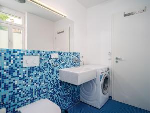 ein Badezimmer mit Waschmaschine und Waschbecken in der Unterkunft Haus SEEGARTEN in Wustrow