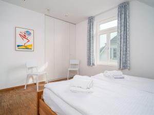 1 Schlafzimmer mit einem Bett mit 2 Stühlen und einem Fenster in der Unterkunft Haus SEEGARTEN in Wustrow