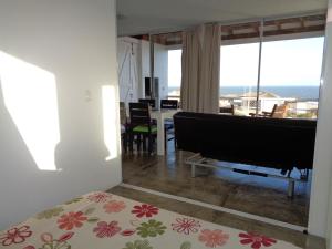 1 dormitorio con piano y sala de estar en Acacias Apartamento D, en Punta del Diablo