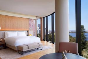a bedroom with a large bed and large windows at The Ritz-Carlton, Perth in Perth