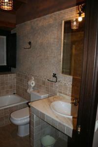 een badkamer met een wastafel, een toilet en een bad bij Casa Don Benito in Arnego