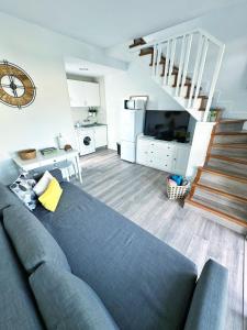 a living room with a blue couch and a staircase at Bungalow Yaipe in Maspalomas