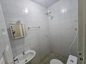 un bagno bianco con un water e un lavandino di Pousada Paz de Mucuripe a Fortaleza