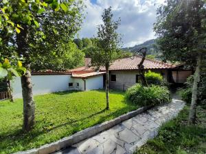 a house with a stone path in front of a yard at Abrigo do verao Maison près du lac in Rio Caldo