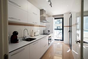 a kitchen with white cabinets and a sink at Hello Cosmo in Estepona
