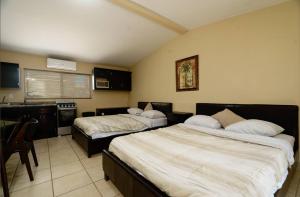 a hotel room with two beds and a kitchen at Rancho Percebu Beach Studio 6 in Don Pancho