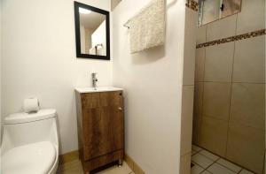 a bathroom with a toilet and a sink and a mirror at Rancho Percebu Beach Studio 6 in Don Pancho