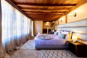 a bedroom with a large bed and a large window at Dar Attajalli in Fez