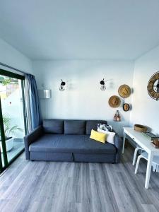 a living room with a blue couch and a table at Bungalow Yaipe in Maspalomas