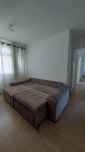 un grande divano marrone in una stanza con finestre di Leonis, Apto 32 a Curitiba