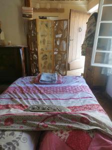 a bed with a quilt on it in a room at hebergement chez l'habitant Hyères Campagne in Hyères