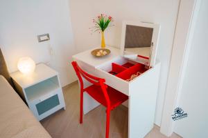 a desk with a red chair and a mirror at Belvedere Valle Mare in San Leone