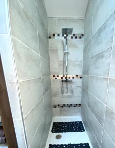 a bathroom with a shower with a black and white tile at Can FRANCES - Maison avec jardin et terrasse proche mer - linge de maison inclus in Villelongue-de-la-Salanque +26 photos