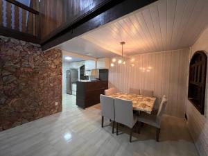 a dining room with a table and a stone wall at Recanto da Natureza in Matinhos