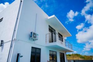 a white house with a blue sky in the background at Villa Boulevard Paradise in Grand Baie