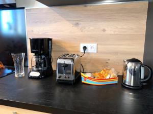 a counter with a toaster and a coffee maker on it at Can FRANCES - Maison avec jardin et terrasse proche mer - linge de maison inclus in Villelongue-de-la-Salanque