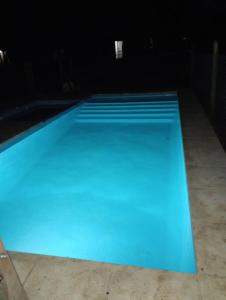 a large blue swimming pool at night at Los 3 soles in Villa Ciudad Parque +13 photos