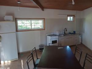 a kitchen with a black table and a refrigerator at Los 3 soles in Villa Ciudad Parque