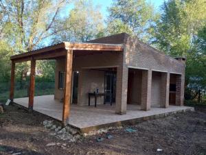 a small brick house with a wooden roof at Los 3 soles in Villa Ciudad Parque
