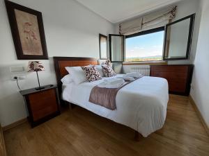 a bedroom with a large bed and a window at El Rincón de Muxiña in Monforte de Lemos +14 photos