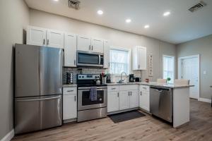 a kitchen with stainless steel appliances and white cabinets at The Penthouse at Park Place King bed fast WIFI and free coffee in Wilmington