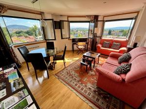 a living room with a red couch and a table at El Rincón de Muxiña in Monforte de Lemos