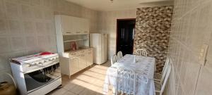 a kitchen with a table and a stove and a refrigerator at Casa para temporada in Ouro Preto