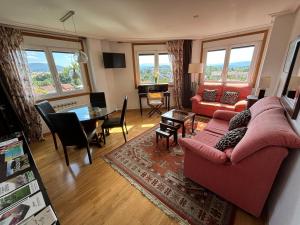 a living room with a red couch and a table at El Rincón de Muxiña in Monforte de Lemos