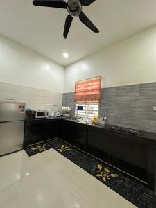 a kitchen with a ceiling fan and a counter at SaRa Homestay in Kuala Terengganu