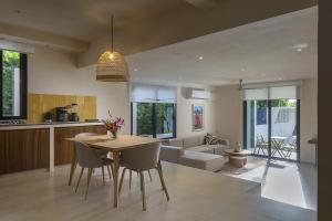 a kitchen and living room with a table and chairs at Ikana Puerto Aventuras Golf Getaway in Puerto Aventuras
