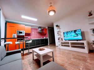 a living room with a couch and a tv at Melo Home 1 Near Airport, Elevator in Vecindario