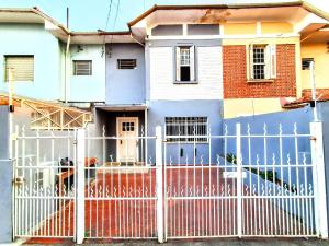 a white fence in front of a house at Sétimo Hostel 7 ll in Sao Paulo