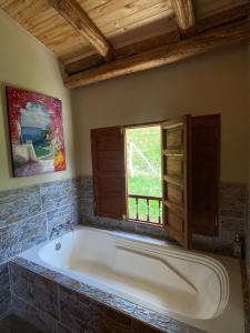 bañera grande en una habitación con ventana en Alojamiento Rural Granja La Ilusión, en Las Esquinas