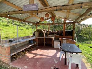 cocina al aire libre con mesa y horno de pizza en Alojamiento Rural Granja La Ilusión, en Las Esquinas