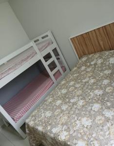 a bedroom with two bunk beds and a stool at Apartamento com varanda - Sahy in Mangaratiba