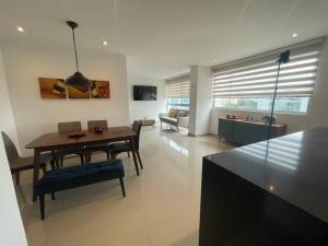 une cuisine et un salon avec une table et des chaises dans l'établissement Confort en el norte de la ciudad, à Ciudad Jardín