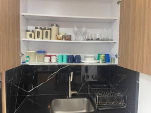 - une cuisine avec un évier et une étagère avec de la vaisselle dans l'établissement Confort en el norte de la ciudad, à Ciudad Jardín 14 autres photos