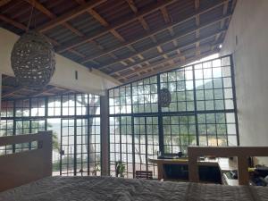 a bedroom with large windows and a bed in a room at Sky Temple Yelapa in Yelapa