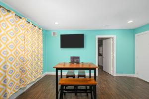 a room with a table and a tv on a wall at Stylish 1BR Apt - Steps from NRG and Texas Med Center in Houston