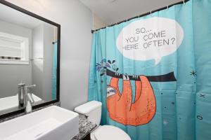 a bathroom with a blue shower curtain with an orange fish on it at Stylish 1BR Apt - Steps from NRG and Texas Med Center in Houston