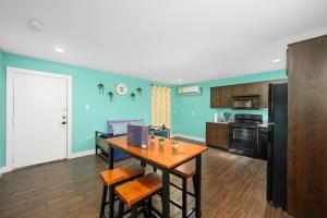 a kitchen with blue walls and a wooden table at Stylish 1BR Apt - Steps from NRG and Texas Med Center in Houston +6 photos