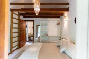 a living room with a couch and a chandelier at Casinha Mandala 2 - Taipu de Fora in Taipu +21 photos