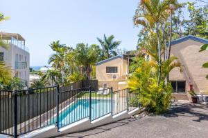 una villa con piscina y palmeras en Otto Descola - Views, walk to Hastings St & beach, en Noosa Heads