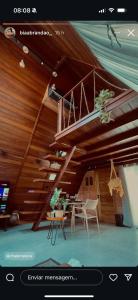 a room with a wooden ceiling with a staircase at Chalé Maloca in Cariry